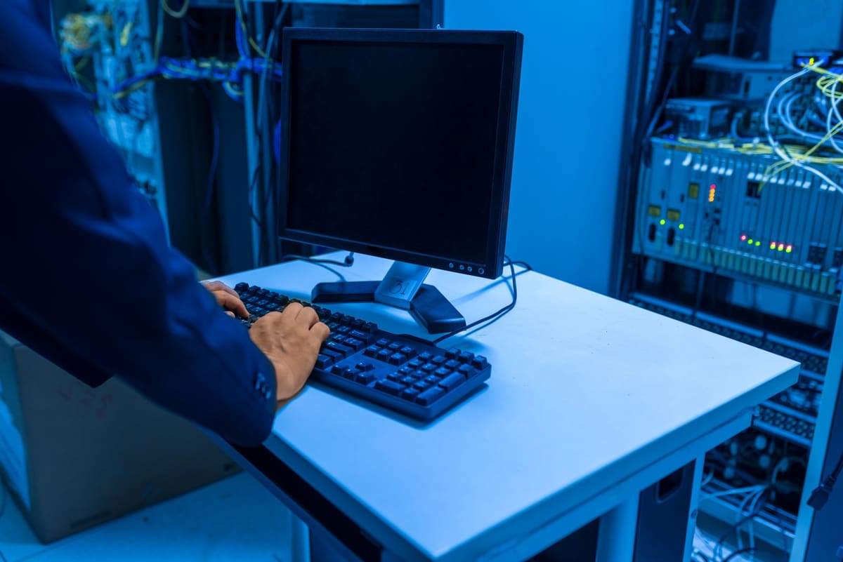 An engineer working at a terminal inside a server room